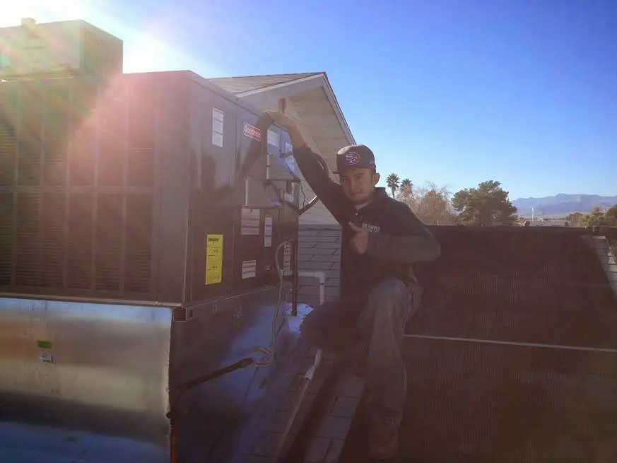 HVAC technician performing AC Tune-Up on a rooftop unit in Milwaukee